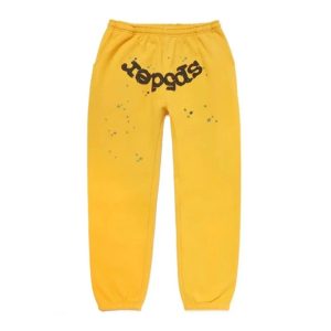 Detailed image of the yellow Sp5der worldwide sweatpants with black writing